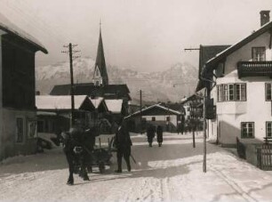 Seefeld. Tirol. Österreich. Winter. Verschneite Straße mit Ochsengespann. Im Hintergrund die Wallfahrtskirche St. Oswald