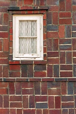 Schönningstedter Straße 24: traufständiges Backsteinhaus mit Doppelwalmdach: Fassade mit besonderem Mauerwerksverband: Detailaufnahme Mauerwerk, kleines Fenster