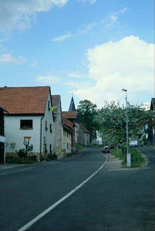 Hauptstraße mit Häusern, hinten Turm der Dorfkirche