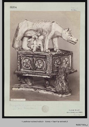 Die kapitolinische Wölfin mit Romulus und Remus auf einem Sockel, der auf drei Löwen ruht