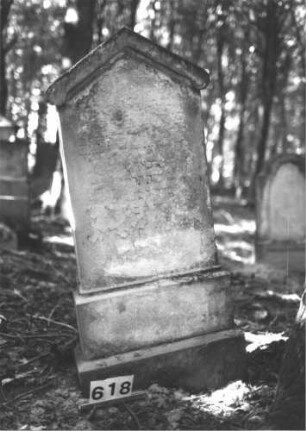 Grabstein 618 (Index: 99900663) Material: Sandstein Zustand: völlig verwittert Maße HxBxT: 132x54x17 cm Beschreibung: aufgesockelte Stele mit Dreiecksabschluss: Grabstein 618