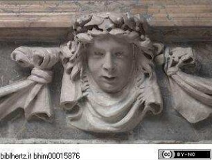 Lorbeerbekrönte Maske am Altar