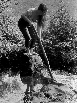 Die Frau des Fotografen an der Schmalen Aue, einem Bach bei Hanstedt. Sie steht auf einem Stein und hält einen Ast in den Bach