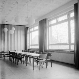 Evangelische Kirchengemeinde Reinfeld: Gemeindehaus: Matthias-Claudius-Straße: vor Einweihung: Innenaufnahme: Saal: mit langem Tisch und Stühlen: rechts Fensterfront: an Decke Kugellampen