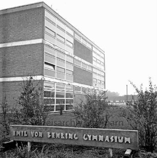 Emil-von-Behring-Gymnasium: Sieker Landstraße: III. Bauabschnitt: Einweihung: Außenansicht: vorn Schild mit Namenszug: dahinter Büsche und Grünanlage: links Schulgebäude: hinten rechts Wohnblocks