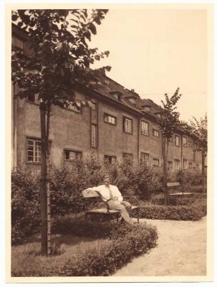 Unzugeordnete Gartenanlagen / Siedlung: Grünanlage mit Baumbepflanzung und Bänken einer zweistöckigen Mehrfamilienhaussiedlung