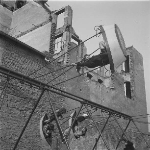 Berlin. Kinder schaukeln vor einer Hausruine