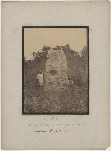 "Large ring-shaped stone on ball playground. (with two members of the expedition)"