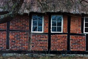 Nütschau: Schloßstraße 42a-c: traufständige Mehrfamilienkate aus Fachwerk mit Reetdach: rückwärtige Traufseite, Teilansicht Mitte: Sprossenfenster