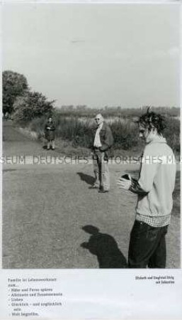 Drei Personen an einem Feld, darunter Text (Sonderthema: Familienbilder)