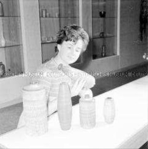 Besucherin der Ausstellung zum Kunsthandwerk in der DDR mit einer Vase