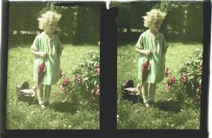 Mädchen mit Puppenwagen im Garten