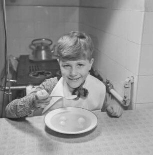 Junge isst Suppe mit Klößchen