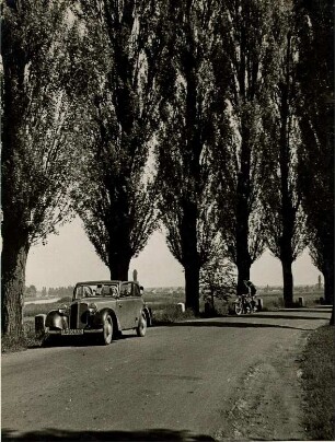 Mit dem PKW unterwegs auf einer Landstraße bei Karlshafen an der Weser. Im Hintergrund ein Motorrad