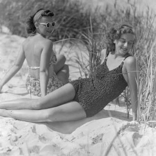 Elisabeth Gremmler (links) und eine Freundin liegen in Badebekleidung am Strand