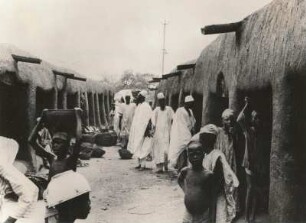 Kano, Nigeria. Marktszene in Kano, Nordnigeria. Einheimische vor den aus Lehm gebauten Kaufhallen
