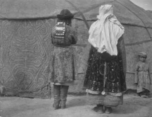 Rückportrait : Rückportrait zweier Personen in traditioneller Kleidung vor einer Jurte im Tian Shan Hochgebirge