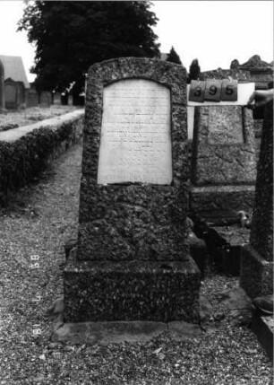 Grabstein 395 (Index: 99797416) Material: Granit, Marmorplatte Zustand: gut Maße HxBxT: 142x51x22 cm Beschreibung: Stele, rustiziert, Segmentbogenabschluß, Sockel: Grabstein 395