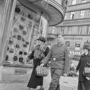 Wehrmachtssoldat mit Schiffchen und Uniform vor einem Taschengeschäft, Soldaten auf Urlaub