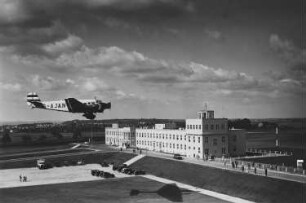 Dresden-Klotzsche. Flughafengebäude mit Parkplatz und landender Ju 52