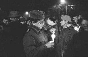 Montagsdemonstration. Volkspolizist mit Kerze