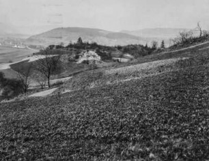 Panoramablick : Panoramablick über eine weite hügelige Landschaft. Links im Hintergrund ein Dorf und landwirtschaftliche Nutzflächen