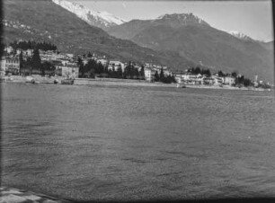 Stadt am See : Panoramablick auf eine Stadt an einem See, im Hintergrund Gebirgszüge mit schneebedeckten Gipfeln