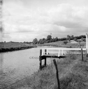 Trave: Bootsanleger unterhalb des Ortes: vorn Zaun: im Hintergrund Knicklandschaft