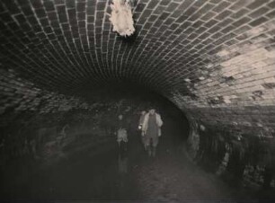 Unter den Straßen von Berlin. Tunnel mit drei Arbeitern