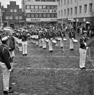 Oldesloer Spielmannszug e.V.: Markt: Entgegennahme der Standarte: Spielmannszug spielt: hinten rechts "Lübecker Nachrichten", "Drogerie Purnhagen": hinten links an Hindenburgstraße "Kaufhaus am Markt - Parco", Hausrat und Porzellan "Otto Möller"