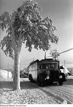 Zinnwald-Georgenfeld (Altenberg-Zinnwald-Georgenfeld). Dreiachsiger Omnibus (Büssing; um 1925) der Kraftverkehr Freistaat Sachsen AG auf einer verschneiten Straße (eingesetzt auf der Eilkraftwagenlinie Dresden - Zinnwald - Teplitz)