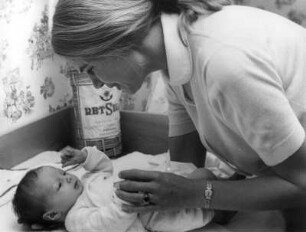 Eine junge Mutter beim Windelwechsel ihres Babys