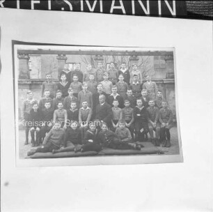 Reproduktion eines Fotos: Gruppenbild einer Schulklasse mit Lehrer