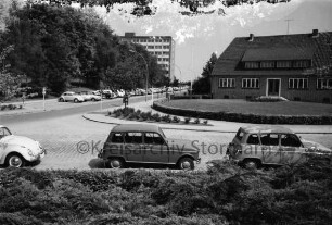 Sülzberg: vorn parkende Pkws: links Einmündung der Bangertstraße mit Parkplätzen und Pkws, Kurpark und Hochhaus der Kreisverwaltung [später Gebäude B]: rechts Gebäude der Kreisverwaltung
