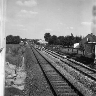 Bahnstrecke zwischen Hamburg und Lübeck: Ausbauarbeiten der Gleise: rechts vorn Baubude, dahinter Haus: Blick auf die Gleise: im Hintergrund Straßenbrücke