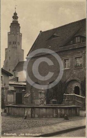 Röhrbrunnen am Marktplatz Fraustadt und Turm der katholischen Pfarrkirche