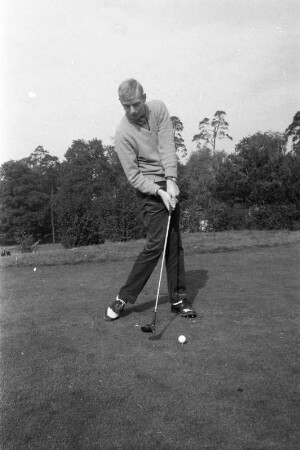 Junger Golfspieler beim Abschlag