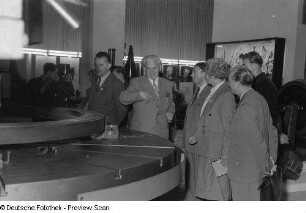 Messebesucher an einem Ausstellungsobjekt