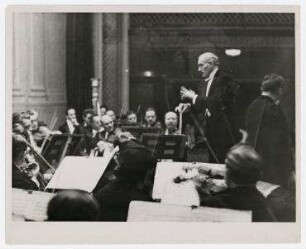Arturo Toscanini dirigiert in Baltimore, Maryland. Konzert mit dem Geiger Adolf Busch. Arturo Toscanini, rechts stehend: Adolf Busch