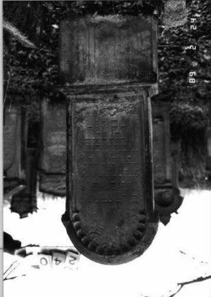 Grabstein 240 (Index: 99752149) Material: Sandstein Zustand: stark verwittert mit Textverlust Maße HxBxT: 149x50x17 cm Beschreibung: profiliert. Sockel, ausgezog. Rundbogenabschluß, Schriftfeld eingetieft Symbolik: Rundbogenfries: Grabstein 240