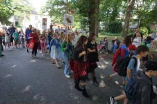 Bad Oldesloe: Kindervogelschießen: Am Bürgerpark, Blickrichtung Westen: Einzug auf den Exer: Festumzug Ida-Ehre-Schule Klassen 6d und 5a, teils mit Verkleidungen: im Hintergrund links Jugendfreizeitstätte (JuZe): 13. Juli 2023