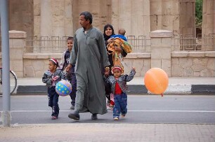 Luxor - Familie auf der Uferstraße : Ägyptische Familie überquert am Luxor-Tempel in Luxor die Uferstraße, aufgenommen 2006