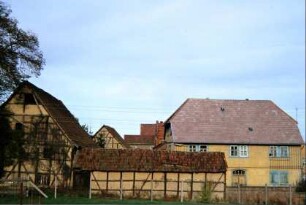 Blick auf das Pfarrgehöft; breite Haustür; Wirtschaftsgebäude