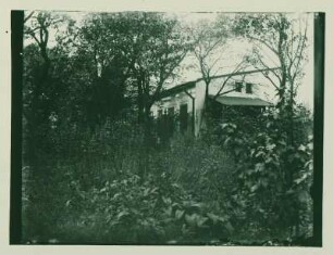 Blick durch den Garten auf das Haus der Eltern