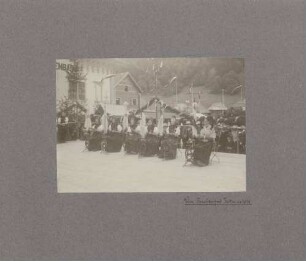 Festbühne mit Frauen in Tracht mit Spinnrädern.