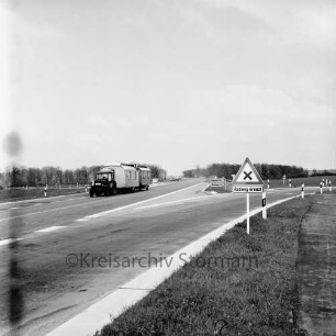 B 404: Abzweigung auf die Landstraße zwischen Mollhagen und Todendorf: vorn rechts Straßenschild: hinten links Zugmaschine mit zwei Baubuden auf Anhänger: im Hintergrund Pkw