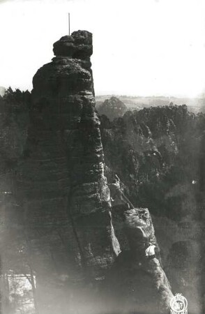 Sächsische Schweiz, Rathener Gebiet. Lokomotive. Ansicht mit springendem Kletterer an der Pfeife (von Osten)
