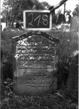 Grabstein 218 (Index: 100103296) Material: Sandstein Zustand: leicht verwittert Maße HxBxT: 72x44x6 cm Beschreibung: Stele, Konvexbogenabschluss, Schriftfeld eingetieft: Grabstein 218