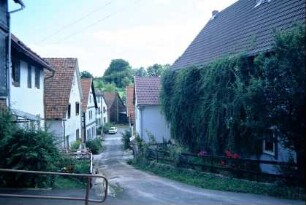 Dorfstraße von der Kirche aus, Häuser und Grünstreifen