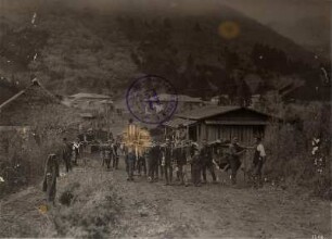 Hakone. Ortsteilansicht mit Touristen in Tragesesseln und einheimischen Trägern